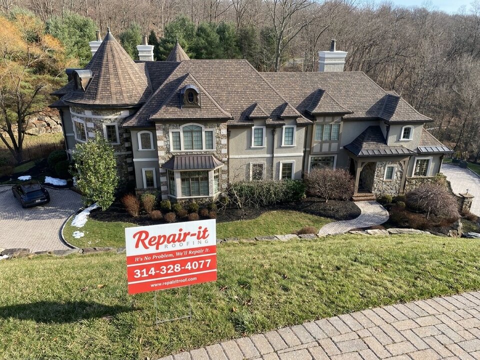 Aerial view of a completed roof with a Repair It Roofing yard sign in the front yard.